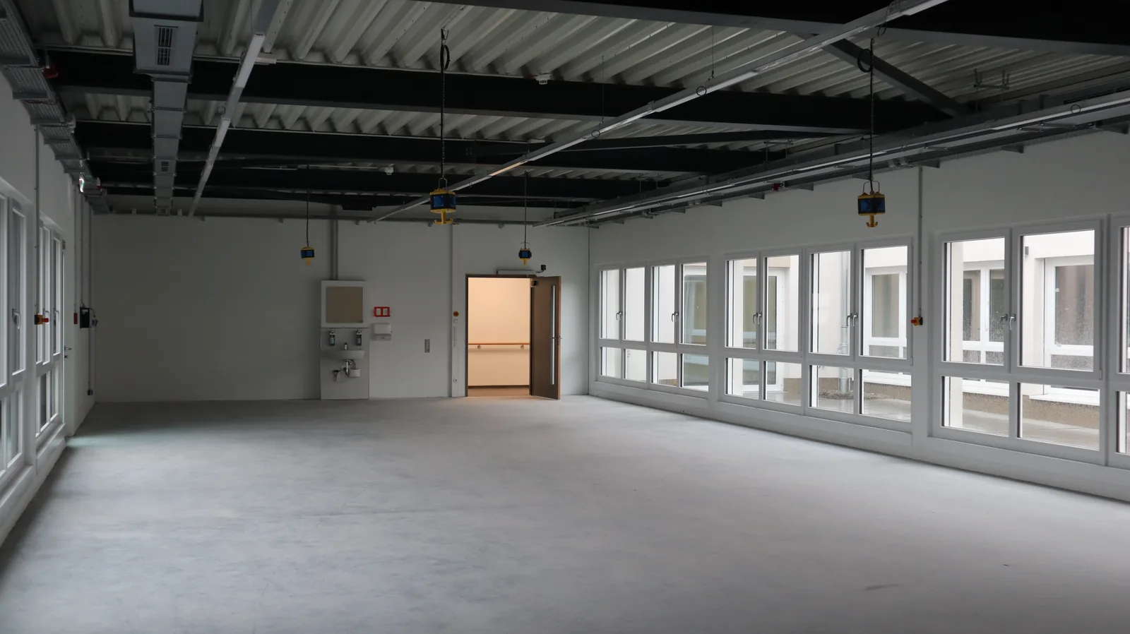 Arbeitsraum an einem Lichthof mit durchgehendem Fensterband und schwellenlosem Boden